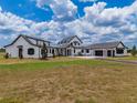 Beautiful exterior of a farmhouse-style home with lush green lawn and manicured landscaping at 3515 Powerline Rd, Lithia, FL 33547