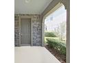 Covered front porch with stone accents, offering a welcoming entry to the home at 4063 Medicci Ln, Wesley Chapel, FL 33543