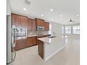 Spacious kitchen featuring a large center island, stainless steel appliances, and modern finishes at 4063 Medicci Ln, Wesley Chapel, FL 33543