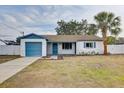Charming single-story home with a well-maintained lawn and a quaint blue-accented garage at 416 Flamingo Dr, Apollo Beach, FL 33572