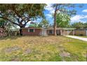 Inviting single-story brick home with a lush green lawn and mature trees providing ample shade at 4512 24Th Ave S, Tampa, FL 33619