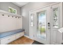 Inviting entryway with custom bench seating, coat hooks, storage, and a beautiful decorative glass front door at 4717 W Lawn Ave, Tampa, FL 33611