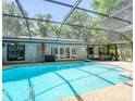 Sparkling pool with an enclosure, surrounded by ample seating, offering a perfect relaxation space at 5153 Miller Bayou Dr, Port Richey, FL 34668