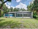 A screened pool enclosure surrounded by lush landscaping providing a private outdoor retreat at 5153 Miller Bayou Dr, Port Richey, FL 34668