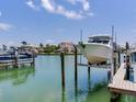 Picture perfect views of the boat lift and waterfront property with clear blue skies at 521 Pinellas Bayway S # 301, St Petersburg, FL 33715