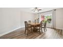 Bright dining room featuring wood floors, elegant wood table with seating for six, and modern ceiling fan at 6703 Towhe Dr, Seffner, FL 33584