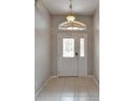 Bright foyer with a decorative glass front door and sidelight at 6801 Bishops Pointe Way, Riverview, FL 33578