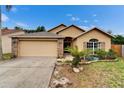 Inviting single-story home featuring a lush front yard, brick accents, and a two-car garage at 6801 Bishops Pointe Way, Riverview, FL 33578