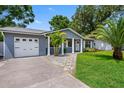 Home exterior features a well-manicured lawn, driveway, and a beautiful facade at 8307 Boxwood Dr, Tampa, FL 33615
