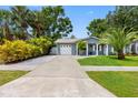 Home's exterior with lush green lawn, grey brick, and convenient driveway at 8307 Boxwood Dr, Tampa, FL 33615