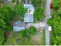 Birds eye of the property with its layout in its wooded surroundings, and its proximity to the road at 10854 Telford St, New Port Richey, FL 34654