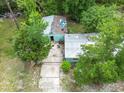 Aerial view of the house showing roof damage and tree coverage, highlighting property's potential at 10854 Telford St, New Port Richey, FL 34654