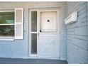 Close-up of a front door with decorative window and mailbox against blue brick exterior at 10900 Queens Rd, Port Richey, FL 34668