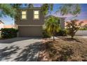 Charming two-story home with attached garage, lush landscaping, and exterior lighting at 10930 Banyan Wood Way, Riverview, FL 33579