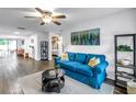 Bright living room featuring a comfortable blue sofa, stylish decor, and modern ceiling fan at 116 W Chelsea St, Tampa, FL 33603