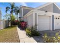 Inviting side view of a lovely townhome with an attached garage and lush green lawn at 12307 Villager Ct, Tampa, FL 33625