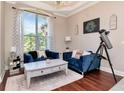 Bright sitting room featuring hardwood floors, cozy seating, a decorative chandelier, and large windows at 12309 Creek Edge Dr, Riverview, FL 33579