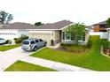 Inviting single-story home with a manicured lawn and a convenient two-car garage at 13327 Waterleaf Garden Cir, Riverview, FL 33579