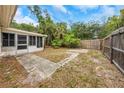 Fenced backyard featuring tropical landscaping and a screened porch area for outdoor living at 1472 Belcher S Rd, Largo, FL 33771