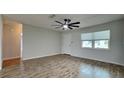 Bright bedroom featuring wood-look floors, a ceiling fan, a large window, and neutral paint at 1701 Hibiscus S Cir, Oldsmar, FL 34677