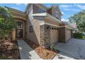 Charming two-story home featuring a three-car garage, landscaped yard, and beautiful entryway at 17809 Sandpine Trace Way, Tampa, FL 33647