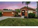 Lovely home featuring a well-manicured lawn, inviting entryway, and an attached two-car garage at 19156 Dove Creek Dr, Tampa, FL 33647