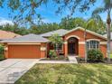 Lovely single-story home showcasing a two-car garage, stucco exterior, and an arched entryway at 19156 Dove Creek Dr, Tampa, FL 33647