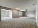 Spacious living room featuring neutral paint, plush carpet, and an airy open floorplan at 2014 Hampstead Cir, Sun City Center, FL 33573