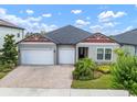 Inviting single-story home with three-car garage and meticulously landscaped front yard at 21648 Snowy Orchid Ter, Land O Lakes, FL 34637