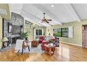 Stylish living room with a stone fireplace, hardwood floors, and ample natural light at 2287 Demaret Dr, Dunedin, FL 34698