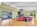 Bright living room with hardwood floors, a stone fireplace, and sliding glass doors leading to the pool at 2287 Demaret Dr, Dunedin, FL 34698