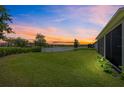 Serene backyard overlooking a tranquil lake at sunset, offering a peaceful and scenic view at 2512 High Tides Way, Wesley Chapel, FL 33543