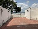 Patio with brick pavers and white picket fence that overlooks a lake at 2557 Cedar Cypress Ct, Tampa, FL 33618