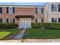 Charming brick townhome with black shutters, a black awning and well-maintained landscaping at 2557 Cedar Cypress Ct, Tampa, FL 33618