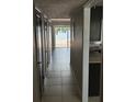 Hallway with tile floors leading to a view of the fenced-in back patio with a lake beyond at 2557 Cedar Cypress Ct, Tampa, FL 33618