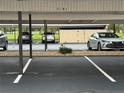 Covered parking featuring multiple cars and numbered spaces at residential building at 2621 Cove Cay Dr # 206, Clearwater, FL 33760