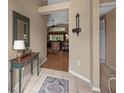 Inviting foyer with tiled flooring, table and view of living area at 26749 Middleground Loop, Wesley Chapel, FL 33544