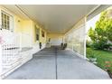 Spacious covered carport with a lattice partition, offering ample parking and outdoor storage, with lush landscaping at 37338 Sandra Ave, Zephyrhills, FL 33542
