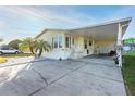 Charming yellow home boasts a covered carport, palm trees, and a well-maintained yard for a welcoming curb appeal at 37338 Sandra Ave, Zephyrhills, FL 33542