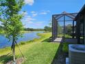 Beautiful backyard with a screened-in lanai and a tranquil lake view, ideal for outdoor living at 3776 Maxwell Park Dr, Sun City Center, FL 33573