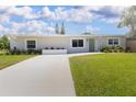 Charming single-story home featuring a well-manicured lawn, vibrant plants and a long drive way at 3951 72Nd N St, St Petersburg, FL 33709