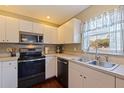 Well-lit kitchen with stainless steel appliances, white cabinets, and a window over the sink at 4555 Hannah Ln, St Petersburg, FL 33709