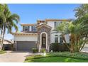 Attractive two-story home with a tile roof, a stone entryway, and lush tropical landscaping at 4612 W Lowell Ave, Tampa, FL 33629