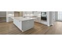 Modern kitchen with white island, countertops, cabinets and stainless steel appliances at 4630 Cedar Fog Ct Dr, Valrico, FL 33596