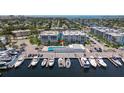 An aerial view showcases waterfront condos with boat docks, community pool, and lush landscaping in a picturesque setting at 4908 38Th S Way # 206, St Petersburg, FL 33711