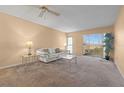 Cozy living room with neutral colors, a ceiling fan, comfortable seating, and a sliding glass door to the outside at 4908 38Th S Way # 206, St Petersburg, FL 33711
