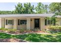 Charming entrance with dark door, updated landscaping, and shuttered windows at 606 Brentwood Pl, Brandon, FL 33511