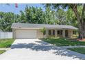 Inviting home featuring a well-kept lawn, mature trees, and a paved driveway at 606 Brentwood Pl, Brandon, FL 33511