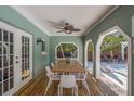 The covered patio features an outdoor ceiling fan, wooden table and chairs, and a view of the backyard at 8240 144Th Ln, Seminole, FL 33776