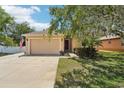 Inviting single-story home features a beige stucco exterior, two-car garage, and an American flag displayed at 9917 Prevatt St, Gibsonton, FL 33534